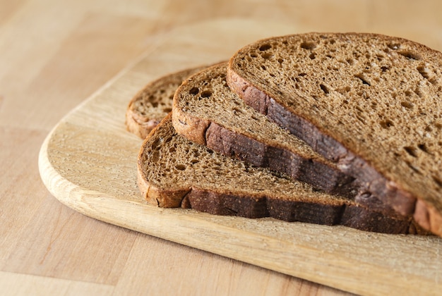 Fette di pane scuro sulla superficie in legno