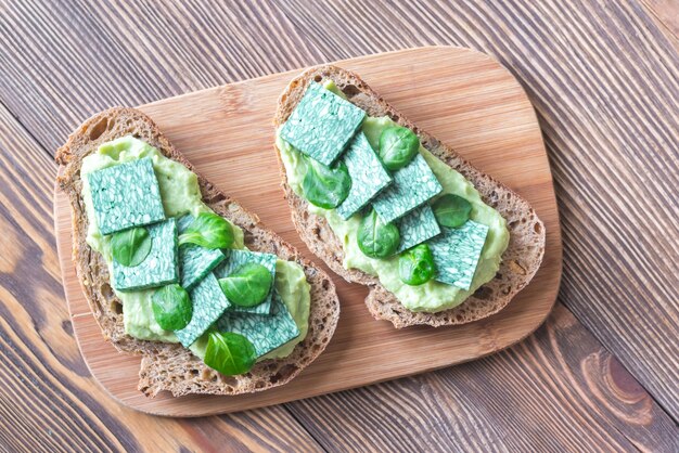 Fette di pane tostato con pasta di avocado e basilico