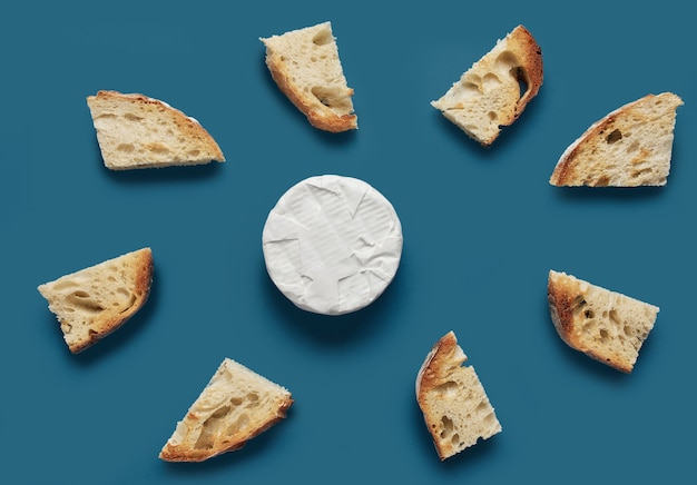 Fette di pane tostato e formaggio brie su sfondo blu scuro, vista dall'alto