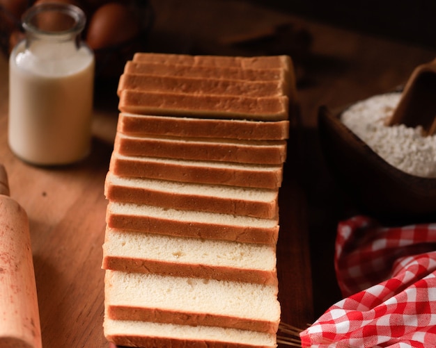 Fette di pane tostato pane bianco (Shokupan o Roti Tawar) per colazione su fondo di legno, servito con uova e latte. Immagine del concetto di panetteria