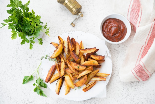 Fette di patata fritte casalinghe con erbe e ketchup, selettivo