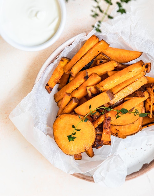 Fette di patate dolci al forno sane fatte in casa con salsa di panna ed erbe Spuntino salutare