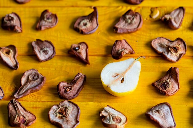 Fette di pere secche delizioso spuntino cibo sano primo piano su uno sfondo di legno