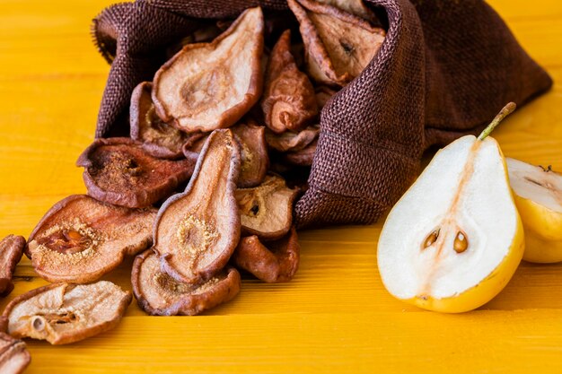 Fette di pere secche delizioso spuntino cibo sano primo piano su uno sfondo di legno