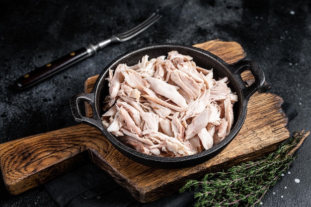 Fette di pezzi di carne di pollo in una padella pollo tirato Sfondo nero Vista dall'alto