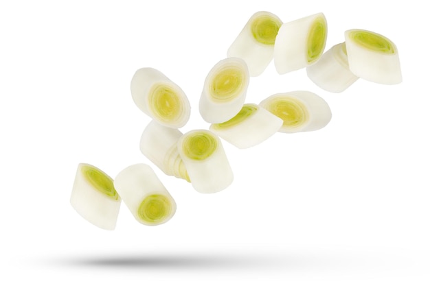Fette di porridge Fette di cipolla bianca e verde isolate su sfondo bianco Un gruppo di fette di porrice di diverse dimensioni e forme sparse in direzioni diverse Foto di alta qualità
