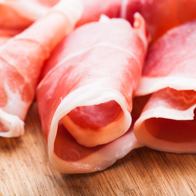 Fette di prosciutto da vicino sul tavolo di legno