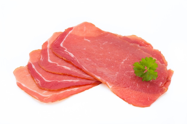 Fette di prosciutto di maiale isolato su priorità bassa bianca.