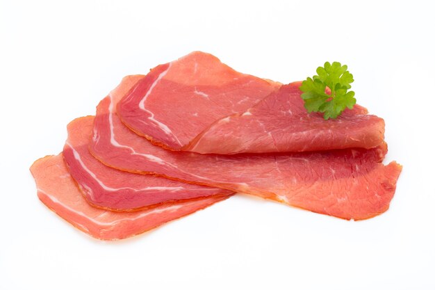 Fette di prosciutto di maiale isolato su priorità bassa bianca