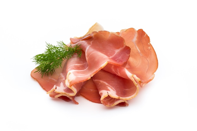 Fette di prosciutto sulla superficie bianca.