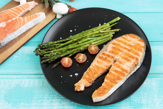 Fette di salmone alla griglia con asparagi verdi. Copia spazio.