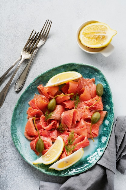 Fette di salmone leggermente salato con capperi, limone e aneto