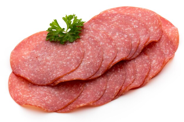 Fette di salsiccia affumicata del salame sulla superficie bianca