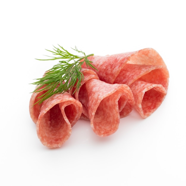 Fette di salsiccia di salame isolato sul ritaglio di tavolo bianco