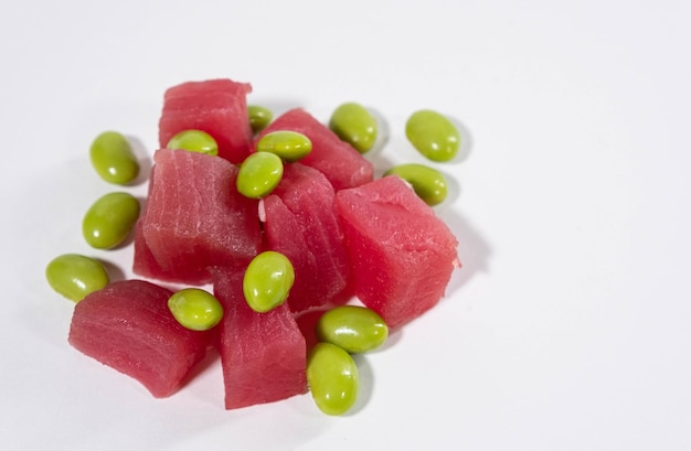 Fette di tonno fresco con fagioli edamame su fondo bianco