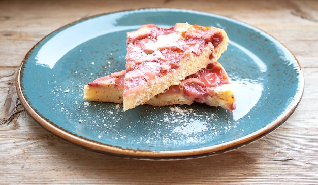 Fette di torta di fragole sulla zolla blu