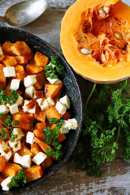 Fette di zucca al forno con fette di formaggio bianco. Insalata tiepida con zucca e formaggio feta. Cibo vegetariano. Mangiare sano