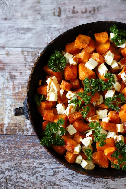 Fette di zucca al forno con fette di formaggio bianco.