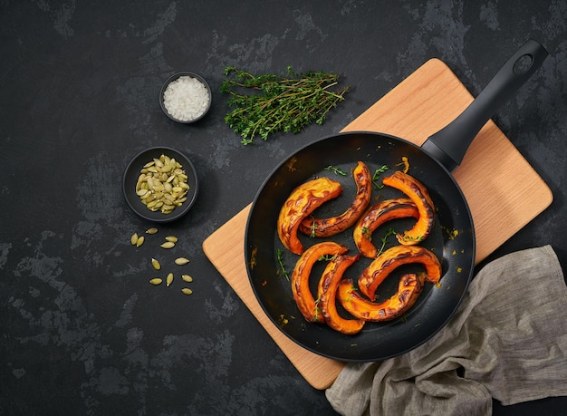 Fette di zucca arrostite in una padella con timo e semi cibo vegetariano sano vista dall'alto