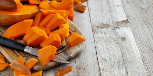 Fette di zucca su uno sfondo di legno bianco da vicino