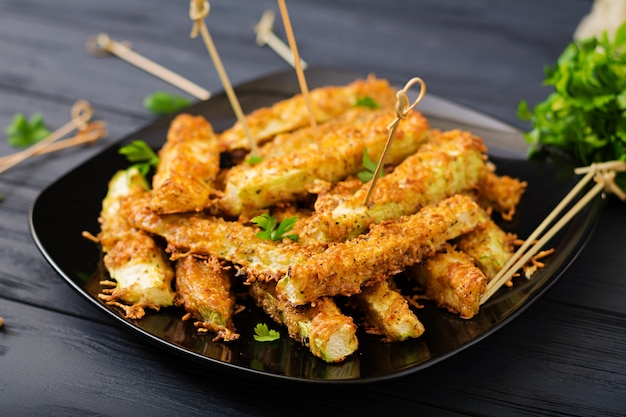 Fette di zucchine cotte sotto l&#39;impanatura di formaggio