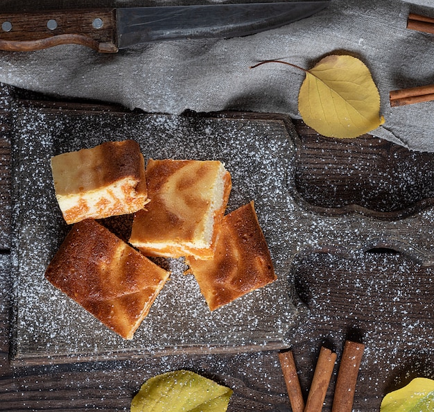 Fette quadrate di ricotta e torta di zucca sul bordo di legno