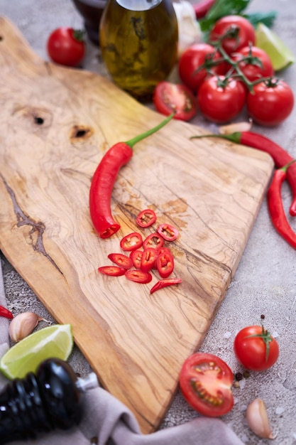 Fette rotonde di peperoncini rossi freschi sul tagliere di legno in cucina domestica