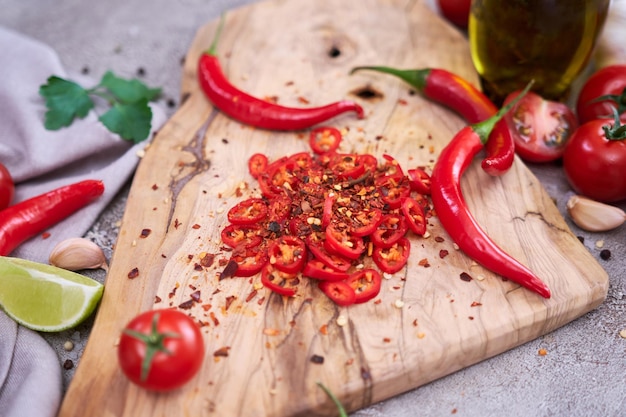 Fette rotonde di peperoncini rossi freschi sul tagliere di legno in cucina domestica