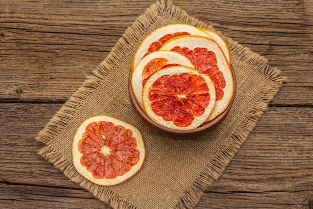 Fette secche di pompelmo in ciotola. Spuntino alla frutta, concetto di mangia sano