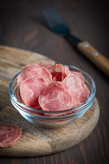 fette sottili salate di carne di manzo a scatti con alto contenuto di proteine servite in una ciotola di vetro sul tavolo