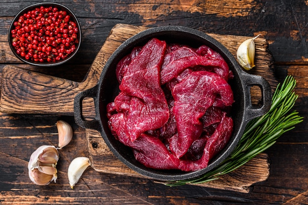 Fette tagliate a dadini crude fresche di carne rossa del filetto del manzo in padella del ghisa