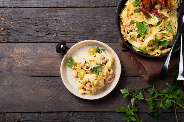 Fettuccine ai frutti di mare con gamberi, polpo e gamberi, su padella di pietra. Piatto gourmet