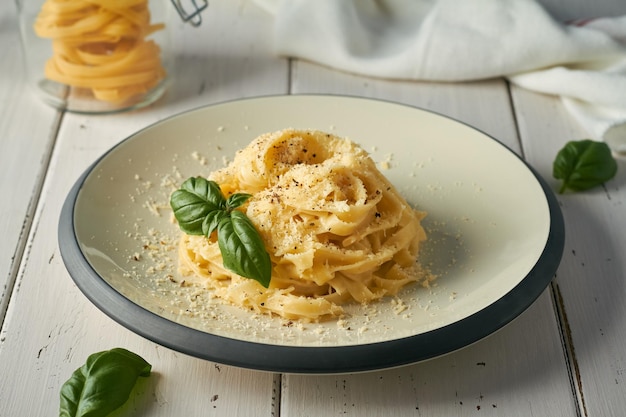 Fettuccine alfredo della pasta italiana con il parmigiano del burro su fondo bianco