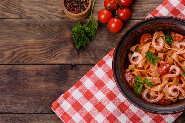 Fettuccine con gamberi, pomodorini, salsa, spezie ed erbe aromatiche. Cucina mediterranea