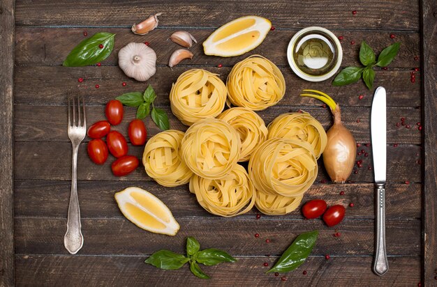 Fettuccine con ingredienti per cucinare la pasta su fondo di legno vista dall'alto