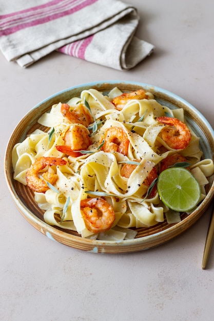 Fettuccine di pasta in salsa cremosa con gamberi, lime e salvia Cibo italiano