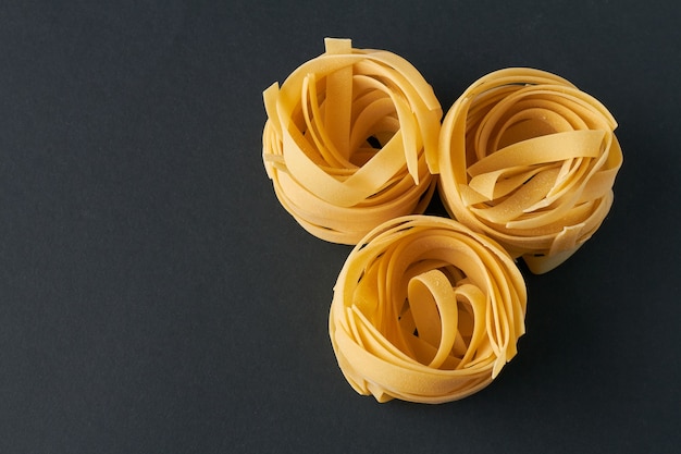 Fettuccine di pasta italiana su sfondo nero