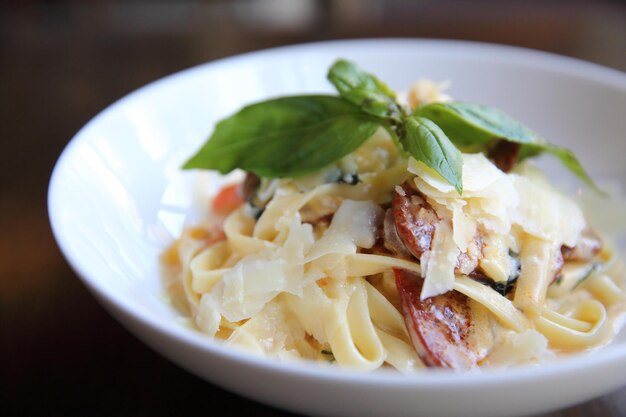 Fettuccine di spaghetti di salsiccia di chorizo su fondo di legno