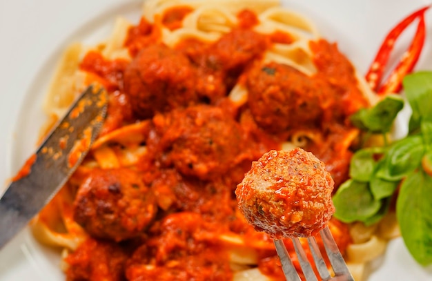 Fettuccine e polpette su un primo piano della forcella