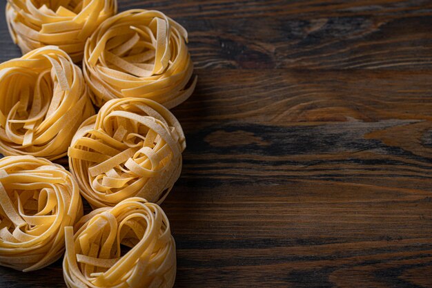 Fettuccine fatte in casa piegate a forma di nido Cucina casalinga con ingredienti per fettuccine fatte in casa della tradizione italiana