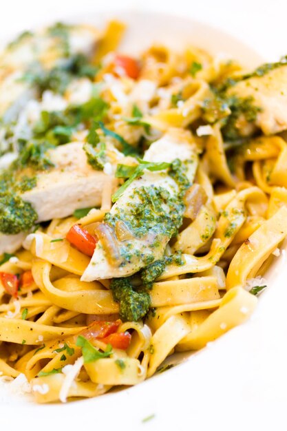 Fettuccine fresche con pollo, peperoni rossi e pesto di basilico.