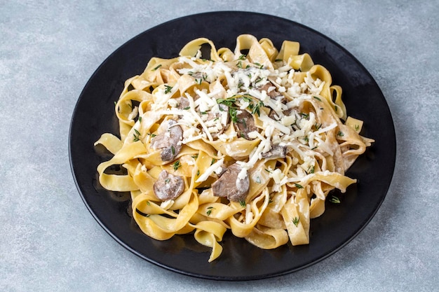 Fettuccine italiane fatte in casa Fettuccine ai Funghi Porcini con funghi e salsa di panna Cucina tradizionale italiana