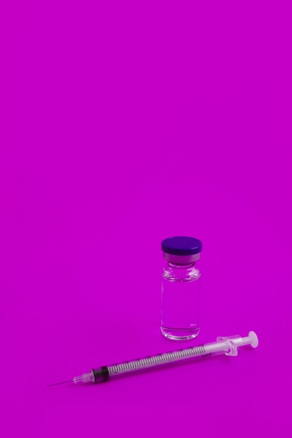 Fiala di siringa con medicina su sfondo rosa