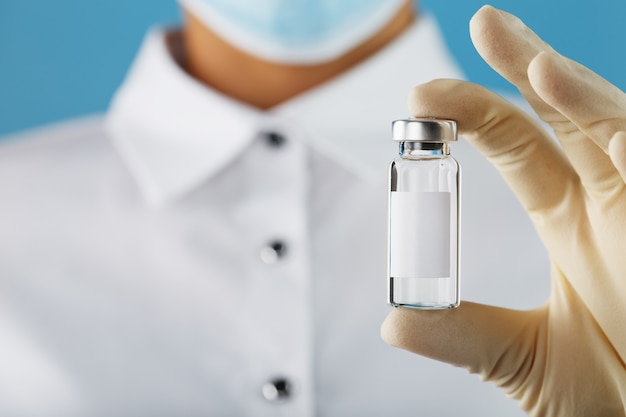 Fiala e siringa nelle mani di un ricercatore medico in guanti di gomma con un vaccino