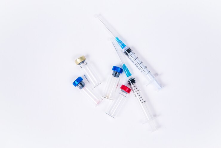 Fiale di vetro veterinarie e mediche e due siringhe per la vaccinazione su uno sfondo bianco isolato