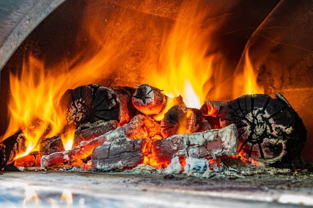 Fiamme rosse, arancioni e gialle da legna da ardere in un forno