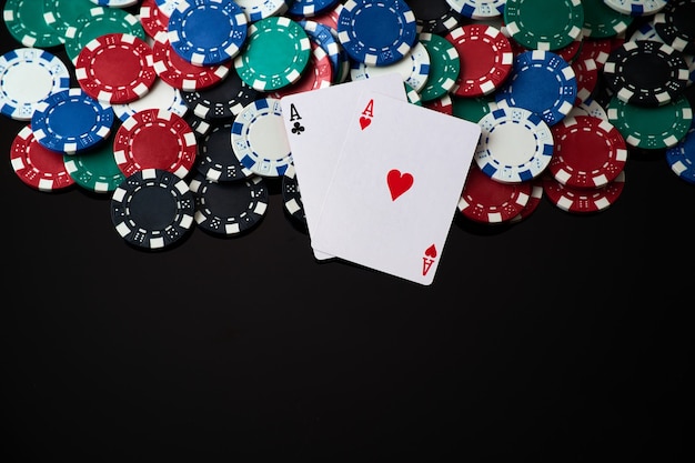 Fiches del casinò e carte da gioco su sfondo riflettente scuro