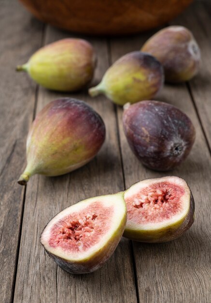 Fichi con frutta tagliata su un tavolo di legno. Profondità di campo ridotta.