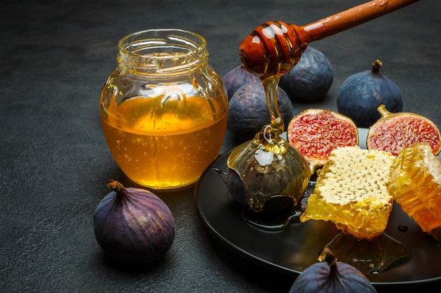 Fichi con miele su un piatto sul tavolo di cemento scuro