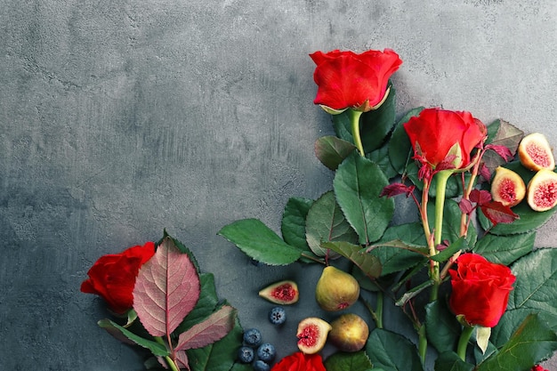 Fichi e mirtilli di belle rose rosse su priorità bassa strutturata di lerciume